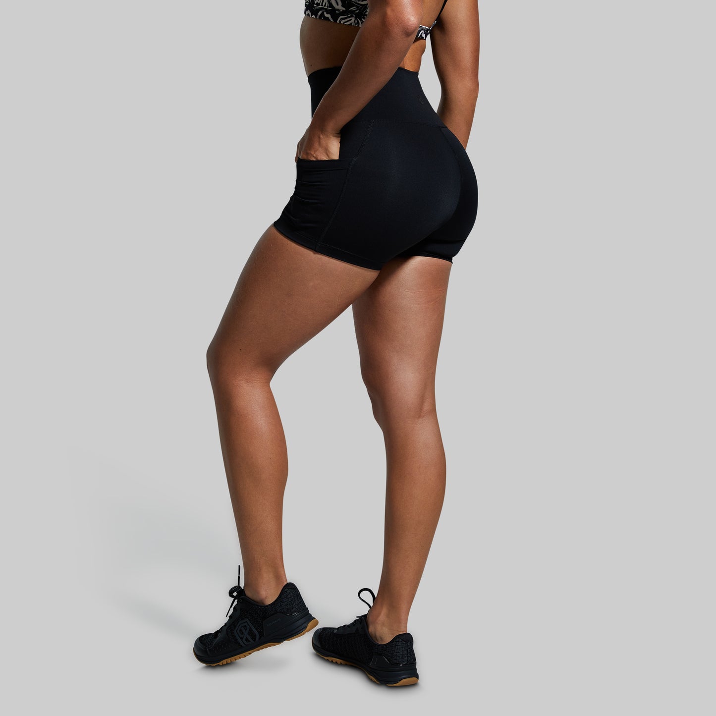Person wearing black athletic shorts on a gray background