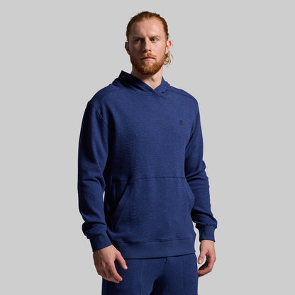 Man wearing a blue hoodie on a gray background