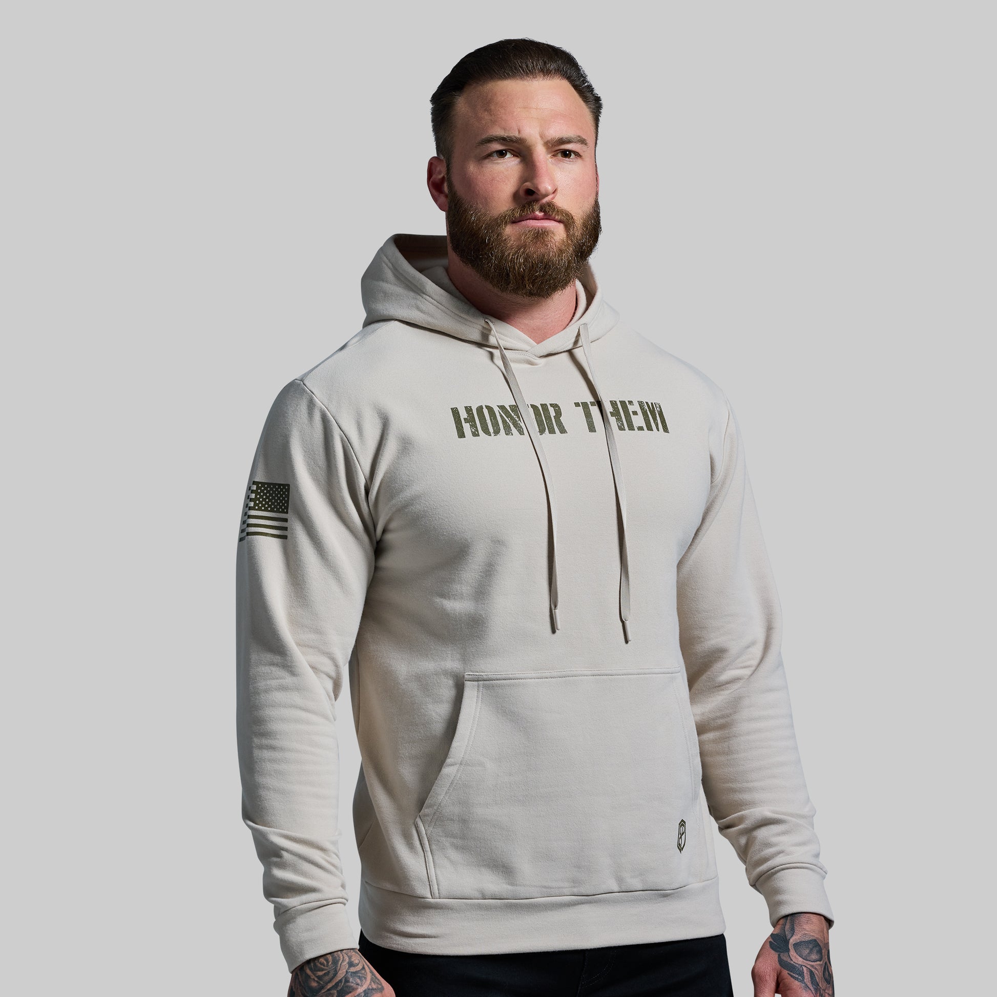 Man wearing a beige hoodie with text on a plain background