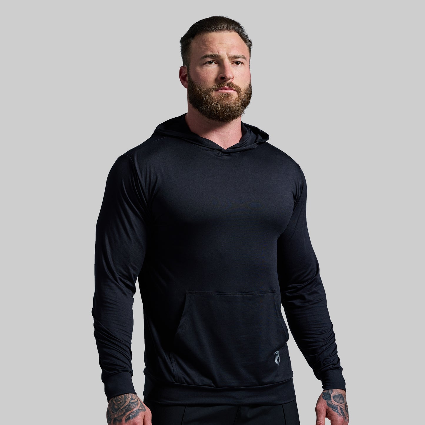 Man wearing a black hoodie against a gray background