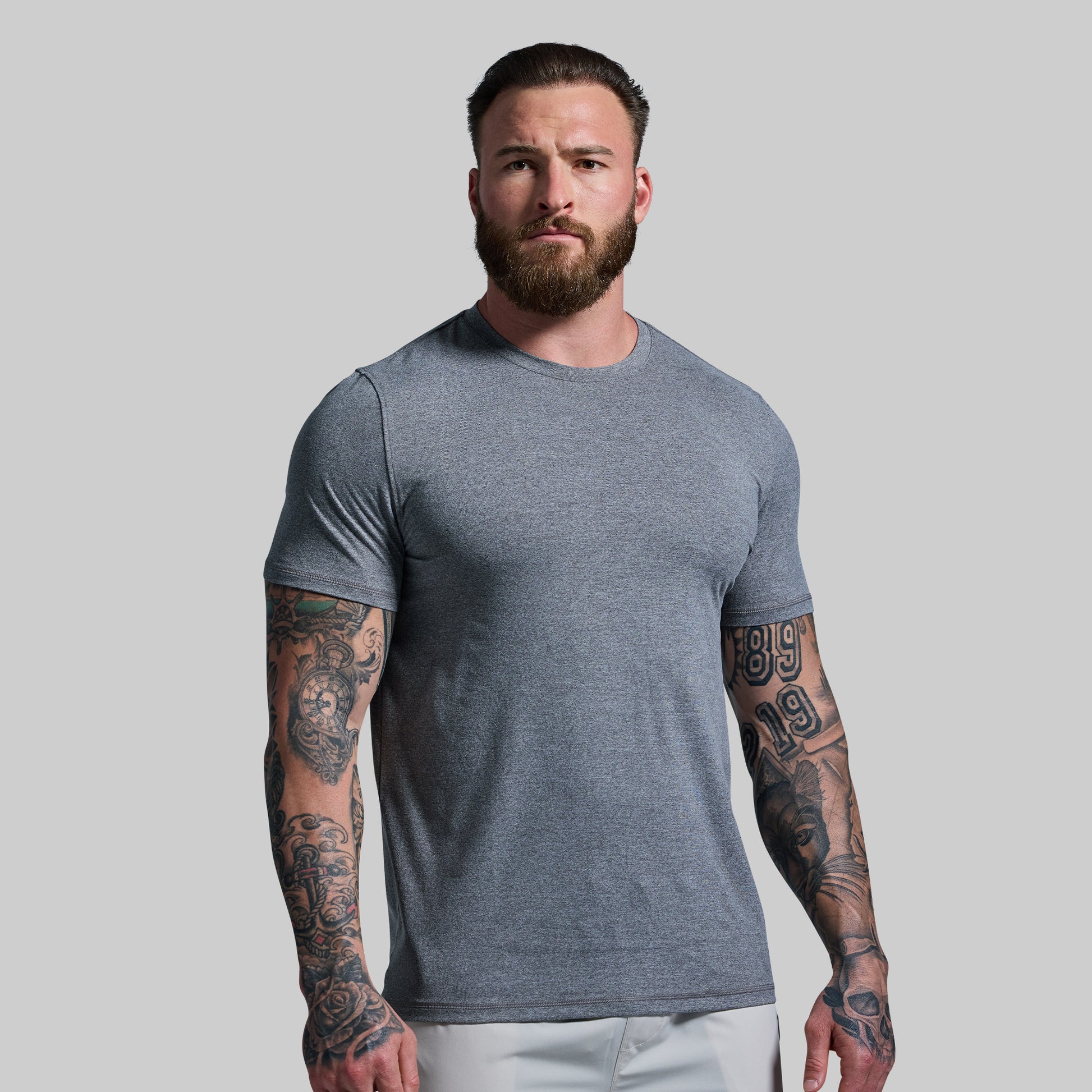 Man wearing a gray t-shirt against a plain background