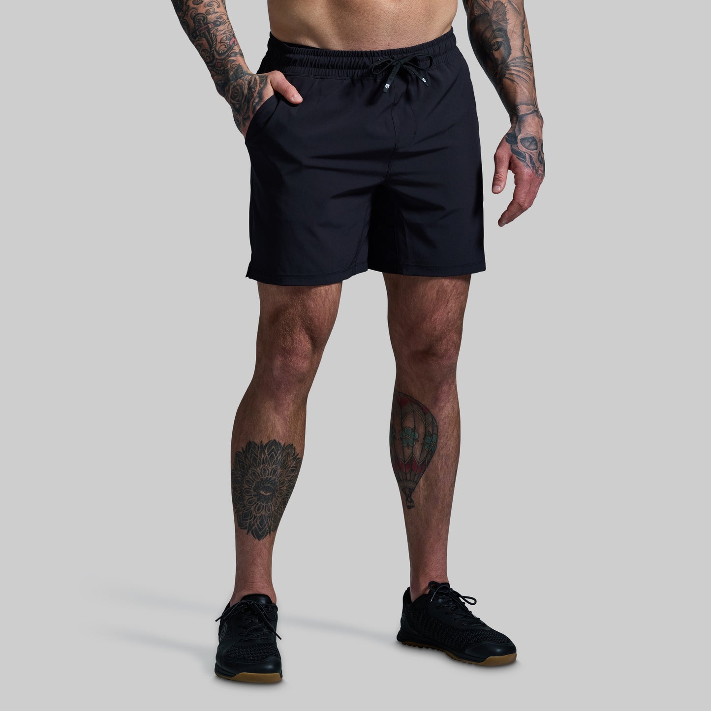 Person wearing black shorts on a gray background