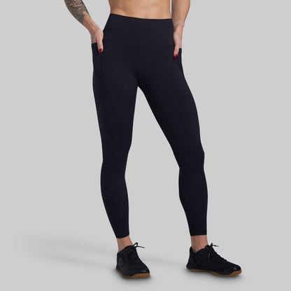 Person wearing black leggings on a gray background