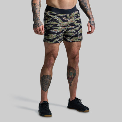 Person wearing camouflage shorts on a plain background