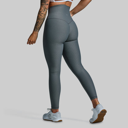 Person wearing gray leggings on a plain background