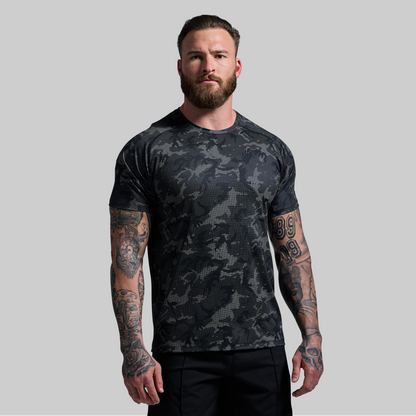 Man wearing a black camouflage t-shirt on a gray background