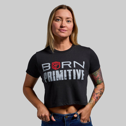Person wearing a black 'Born Primitive' t-shirt on a gray background