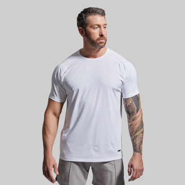 Man wearing a white t-shirt and gray shorts against a plain background