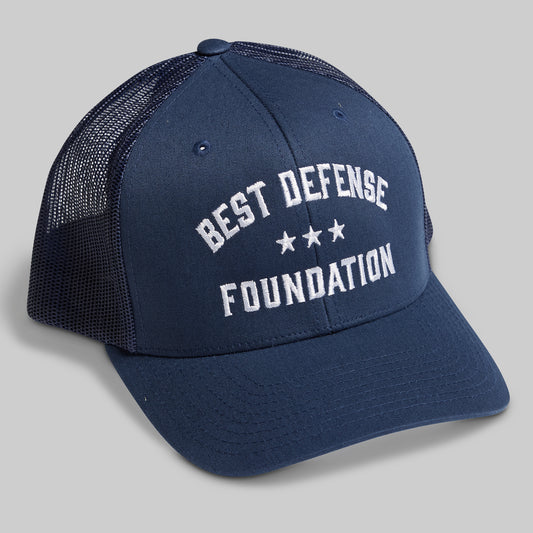Navy blue cap with 'Best Defense Foundation' text on a gray background