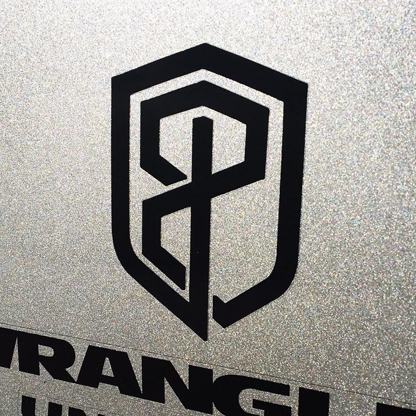 Black logo on a metallic surface.