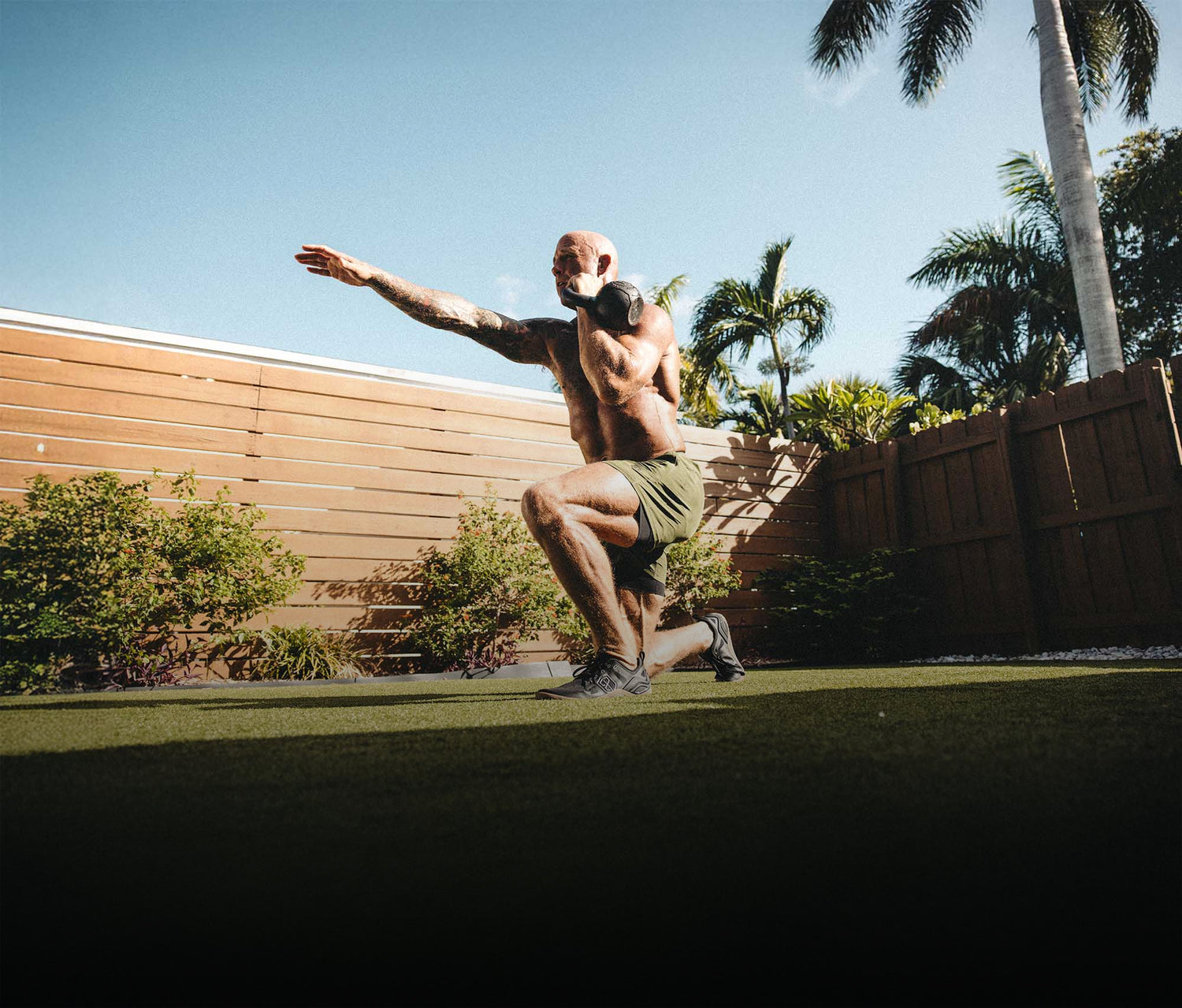 Barefoot athlete doing walking kettle bell lunges 