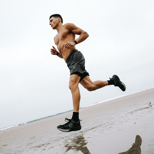 Man running on a beach with a clear sky
