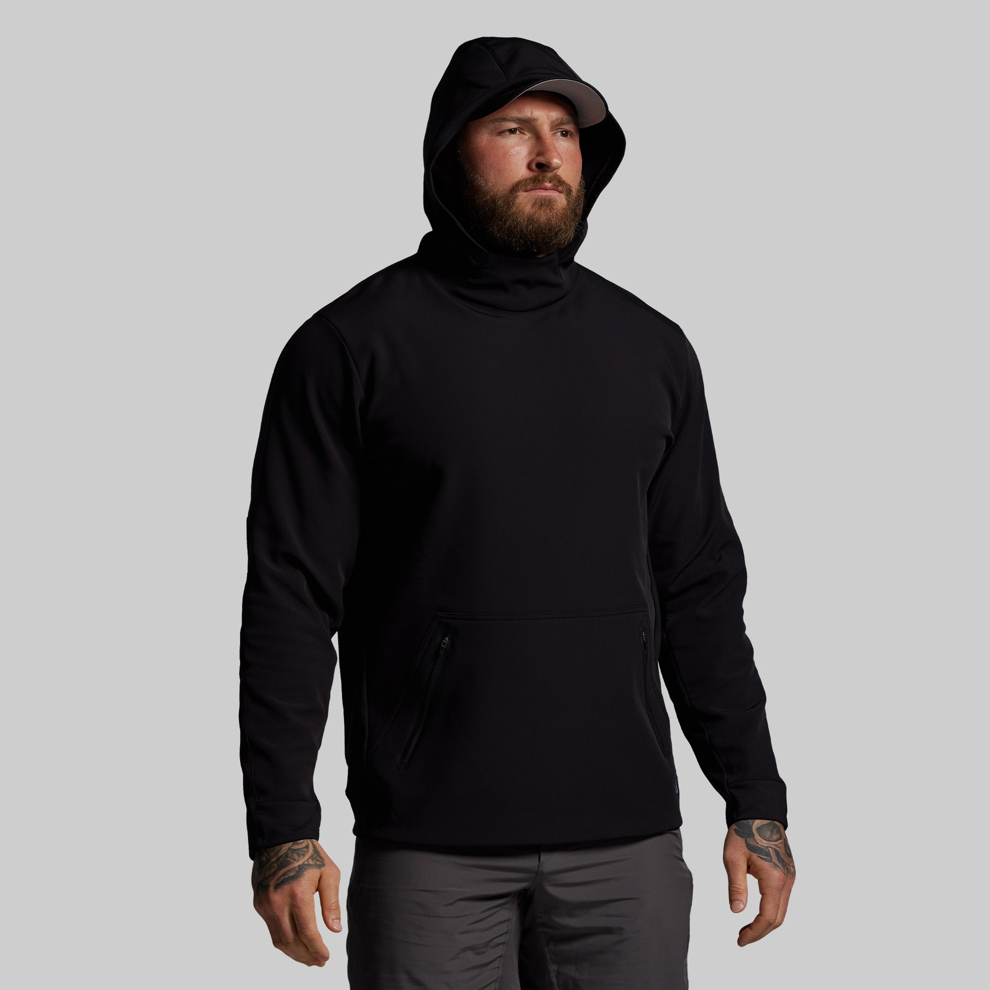 Man wearing a black hoodie on a gray background