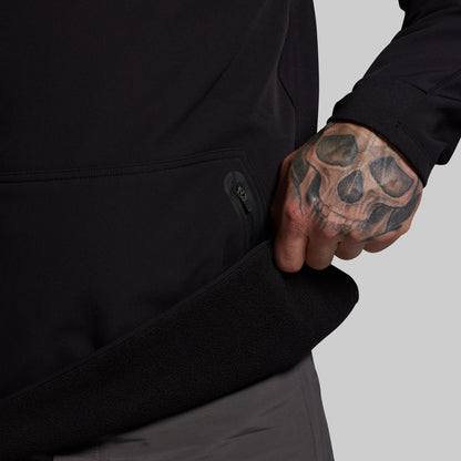 Person wearing a black jacket with a tattooed hand on a gray background
