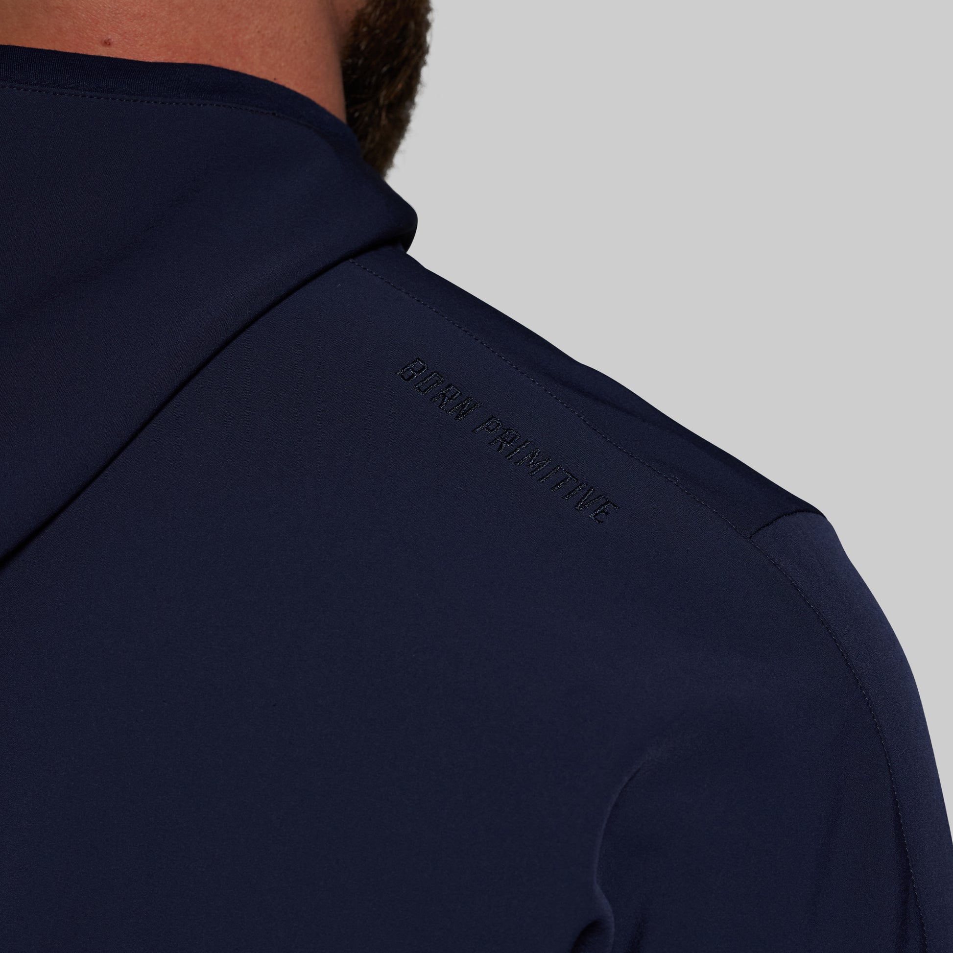 Navy blue hoodie with brand logo on a gray background
