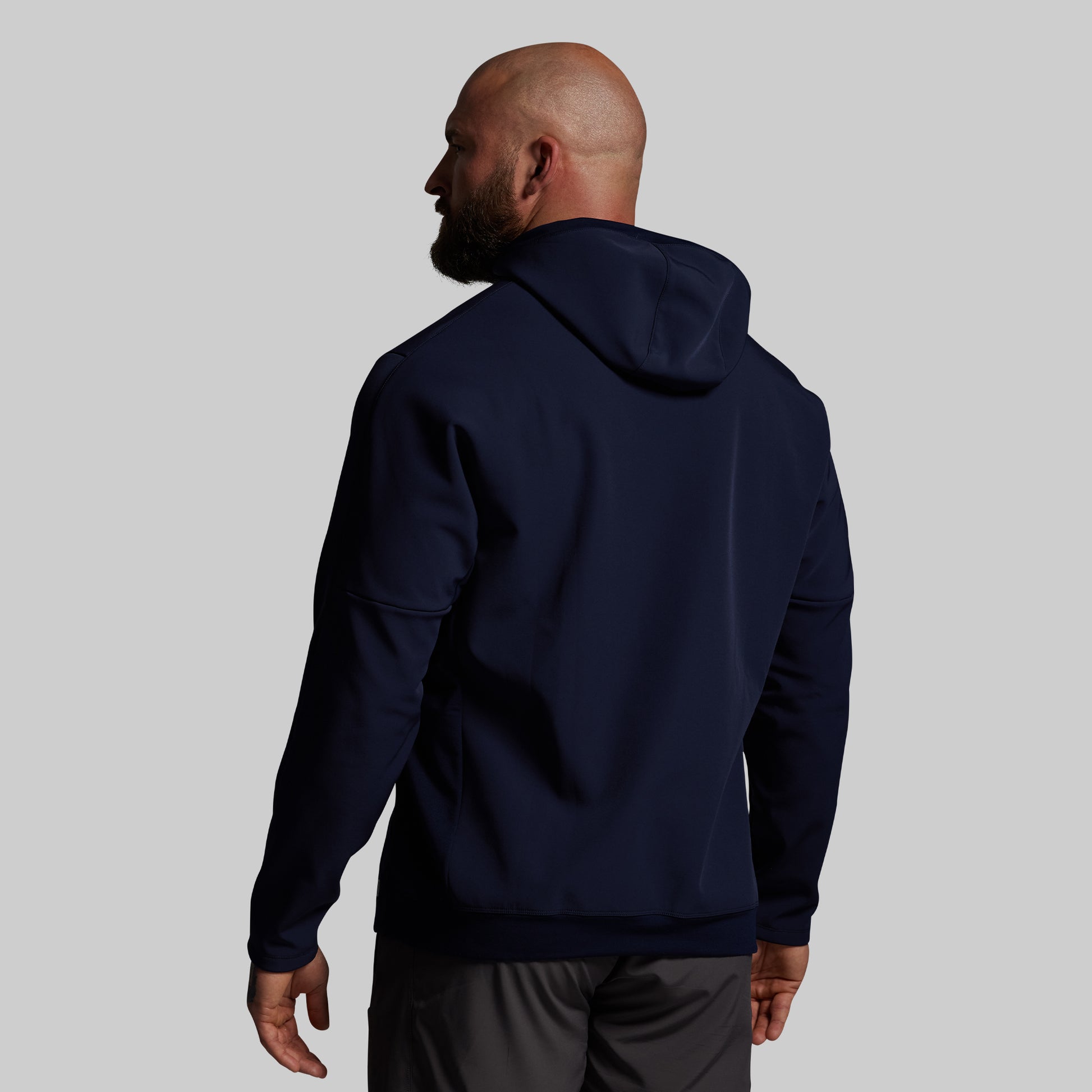 Man wearing a navy blue hoodie on a light gray background