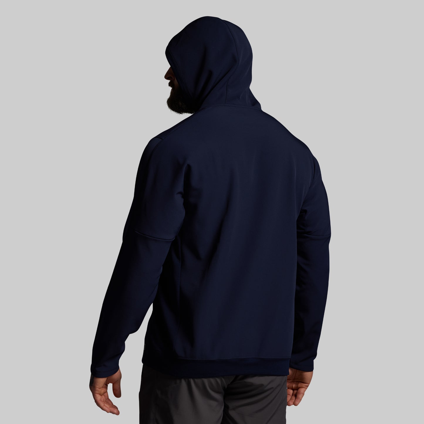 Person wearing a navy blue hoodie on a light gray background