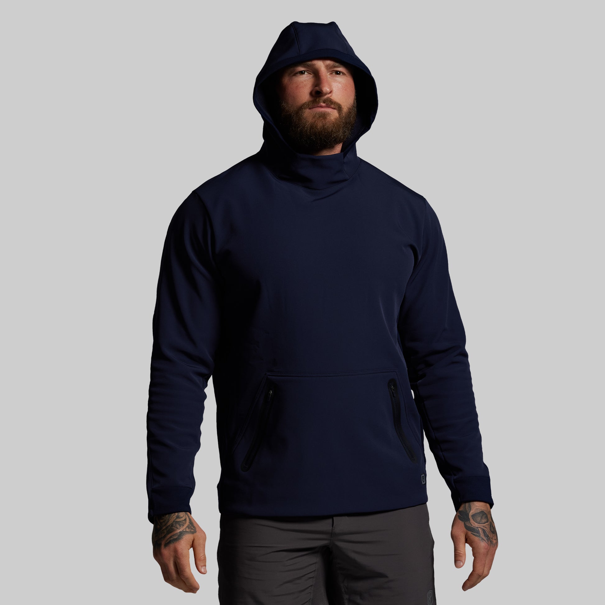 Man wearing a navy blue hoodie on a gray background