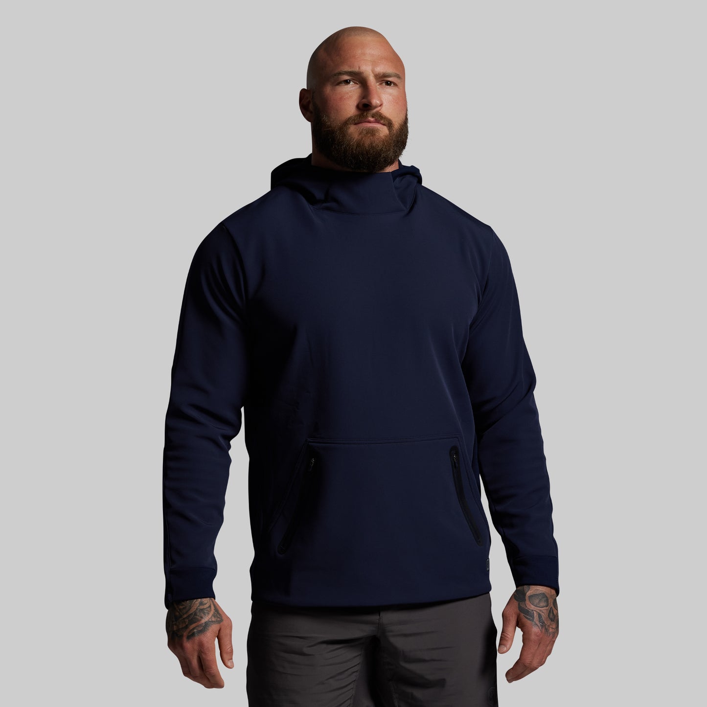 Man wearing a navy blue hoodie on a gray background
