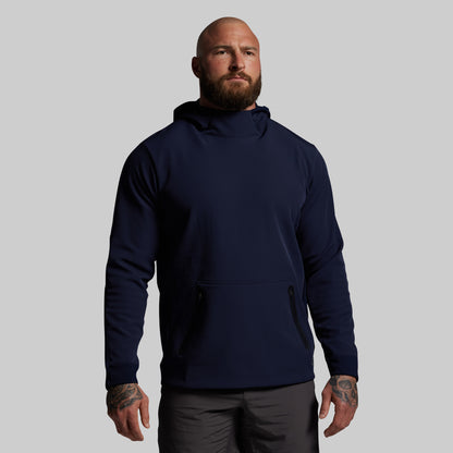 Man wearing a navy blue hoodie on a gray background