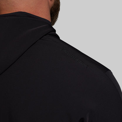 Blue jacket with 'Born Primitive' branding on a gray background