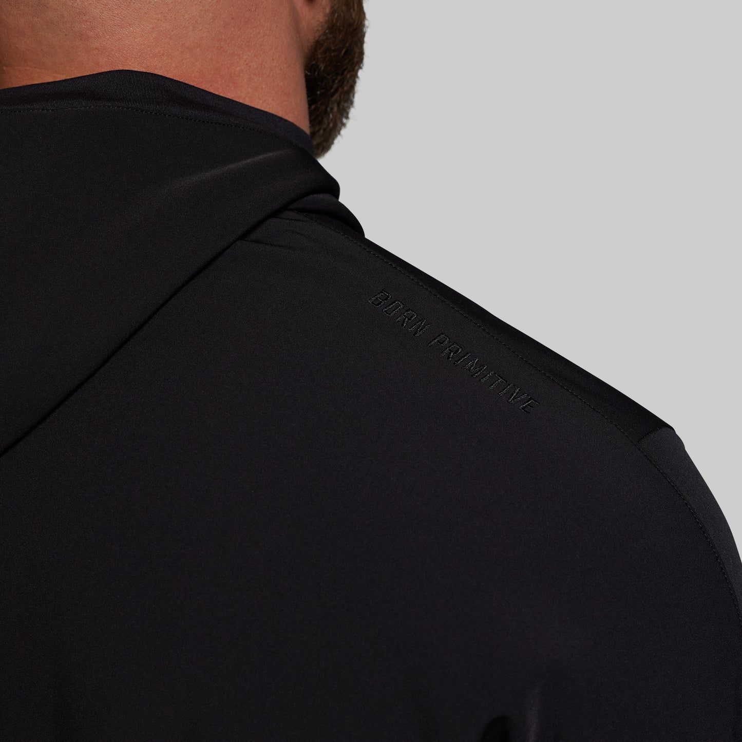 Black hoodie with 'Born Primitive' branding on a gray background