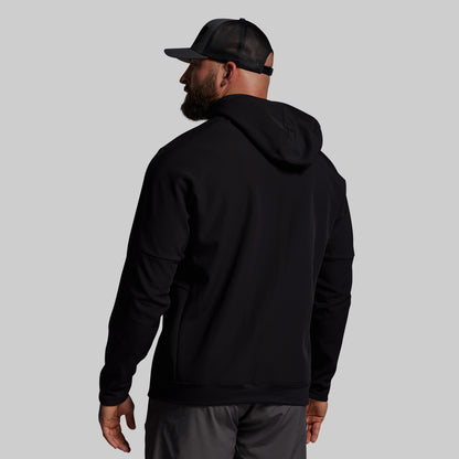 Man wearing a black hoodie and cap from behind on a light gray background