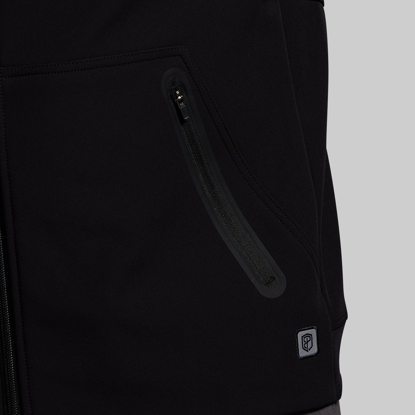 Close-up of a black jacket with a zipper pocket on a gray background