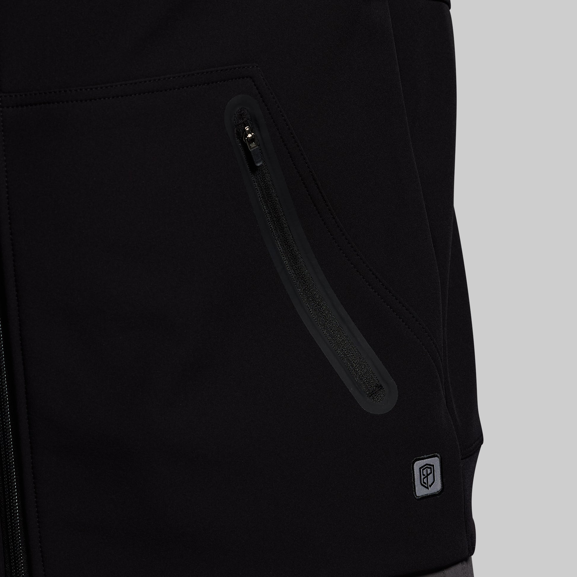 Close-up of a black jacket with a zipper pocket on a gray background