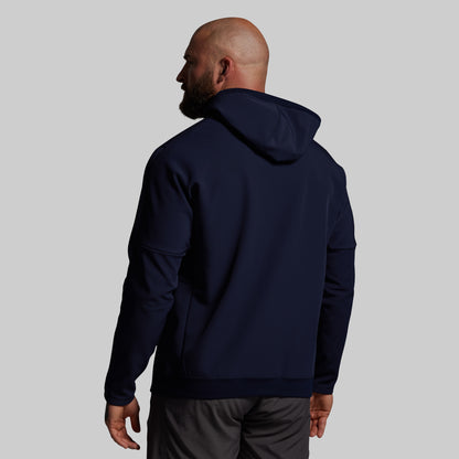 Man wearing a navy blue hoodie on a plain background