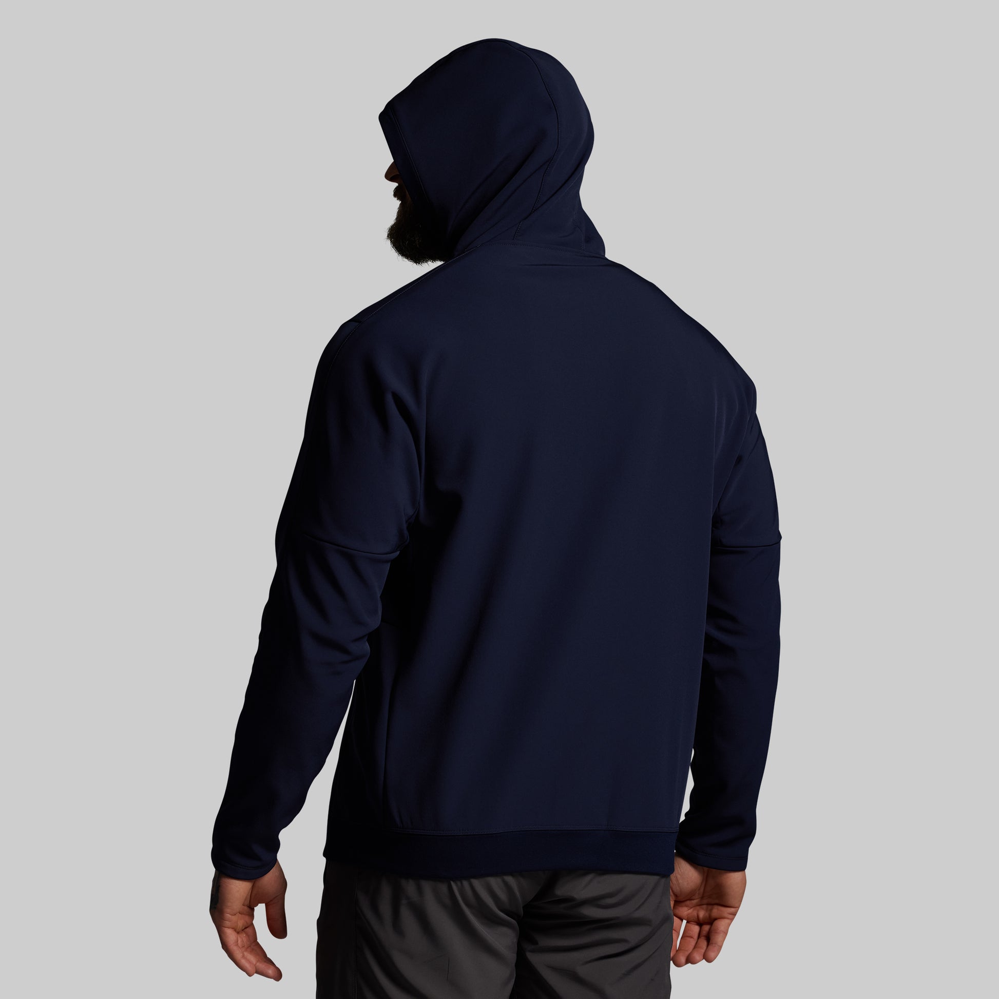 Person wearing a navy blue hoodie on a light gray background