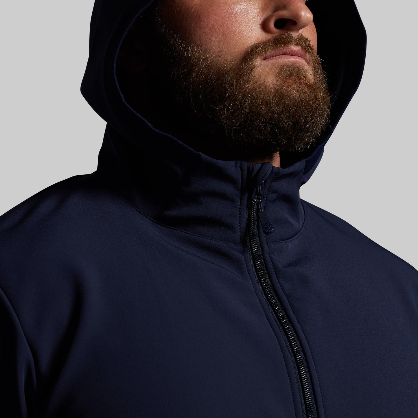 Man wearing a navy blue hoodie on a gray background