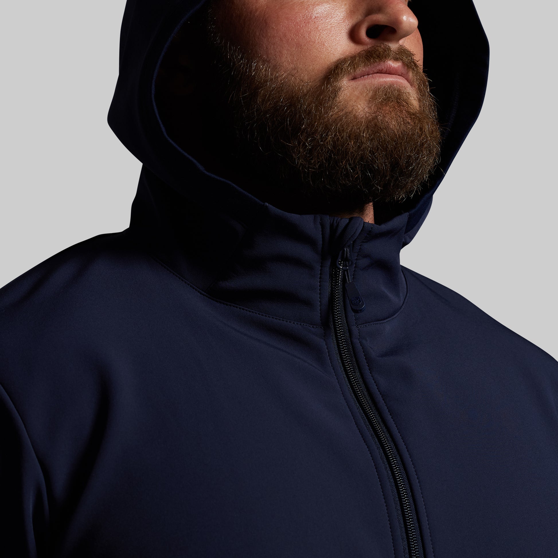 Man wearing a navy blue hoodie on a gray background