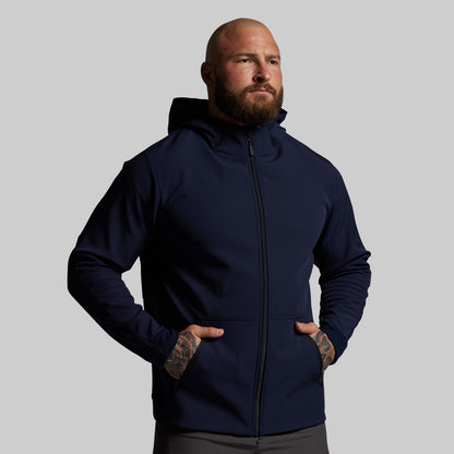 Man wearing a navy blue hoodie against a gray background