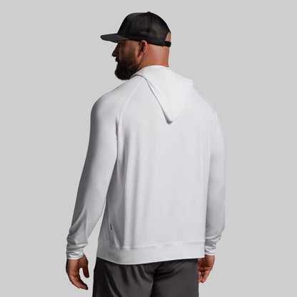 Person wearing a white hoodie and black cap on a gray background