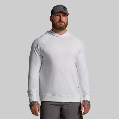Man wearing a white long-sleeve shirt and gray cap on a gray background