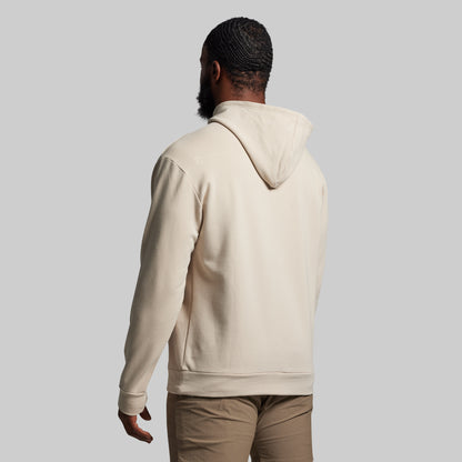 Person wearing a beige hoodie from behind on a light gray background