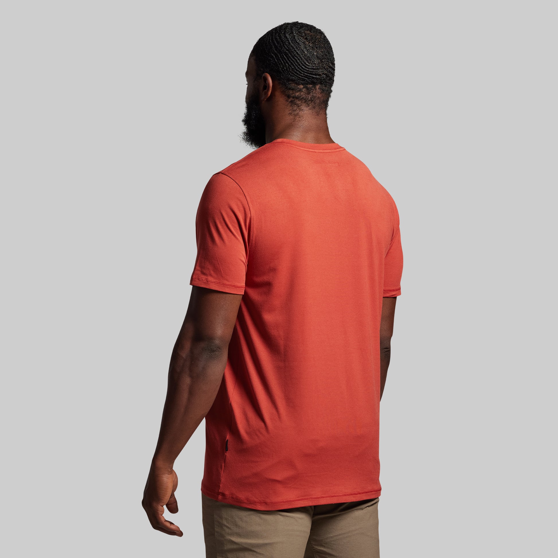 Person wearing a red t-shirt against a gray background