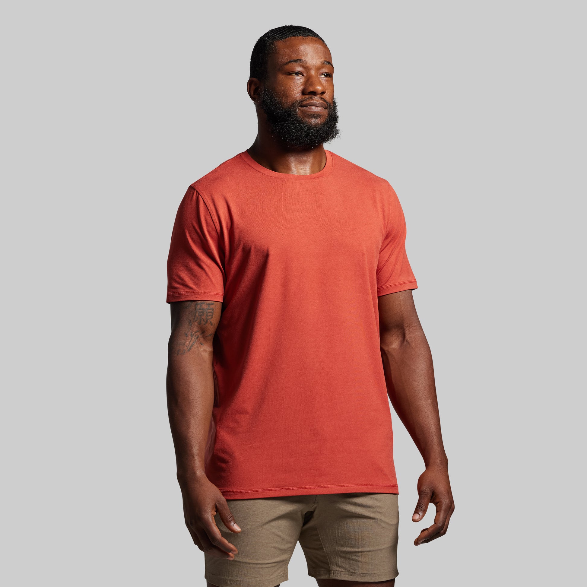 Man wearing a red t-shirt against a gray background