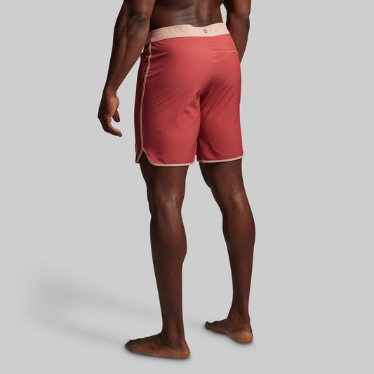 Person wearing red board shorts on a gray background