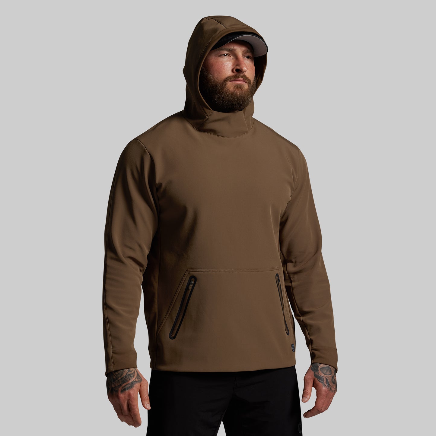 Man wearing a brown hoodie on a gray background
