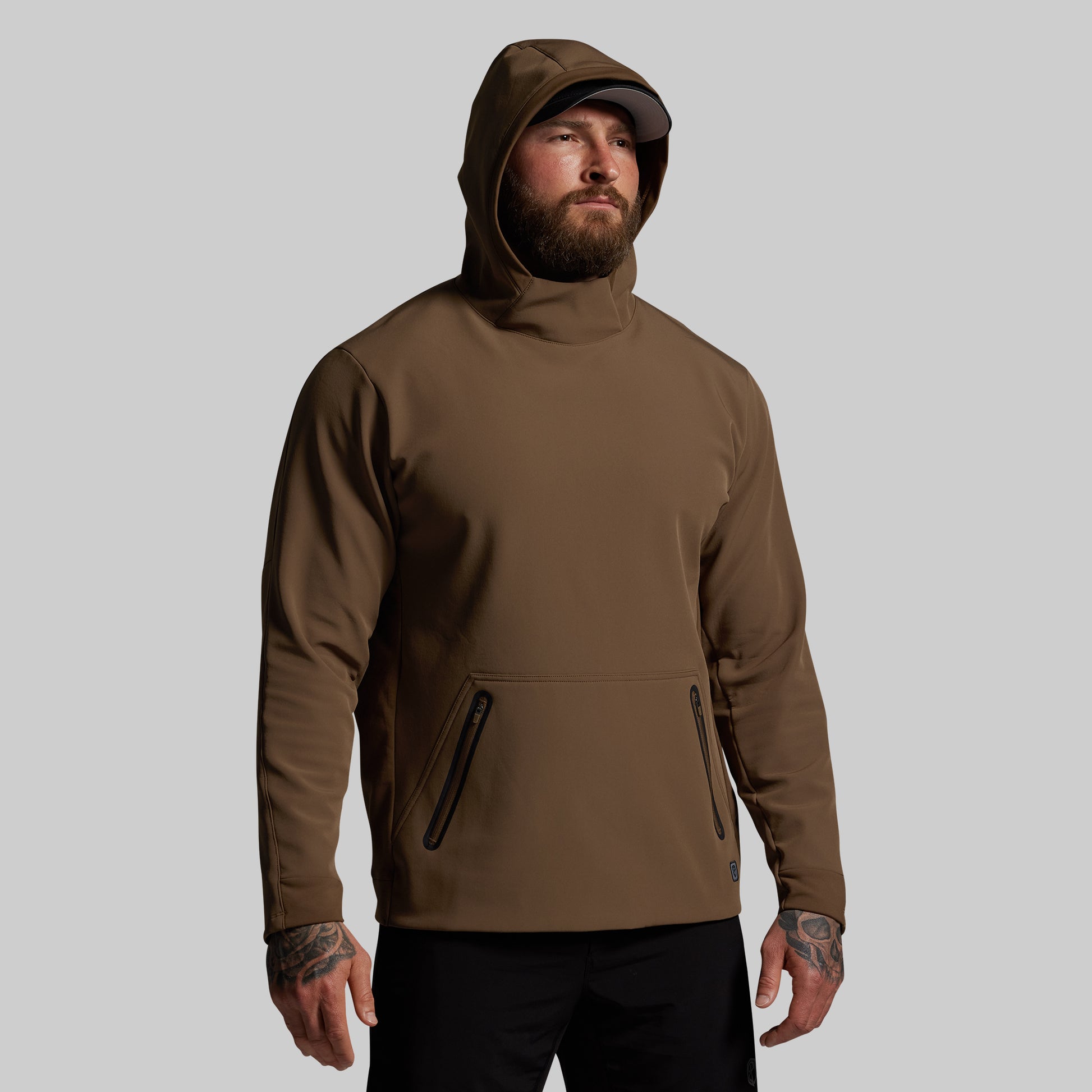 Man wearing a brown hoodie on a gray background