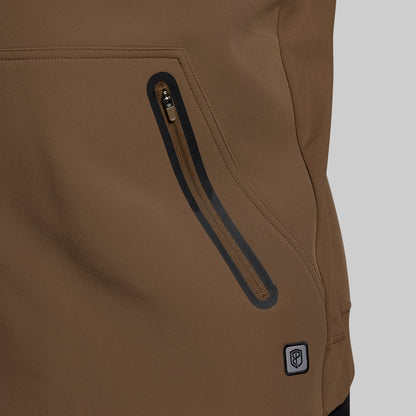 Close-up of a brown jacket with a zipper and brand logo on a gray background