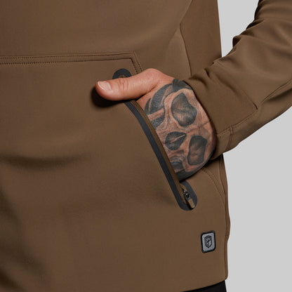 Brown jacket with a hand reaching into a pocket, showing a tattooed arm.