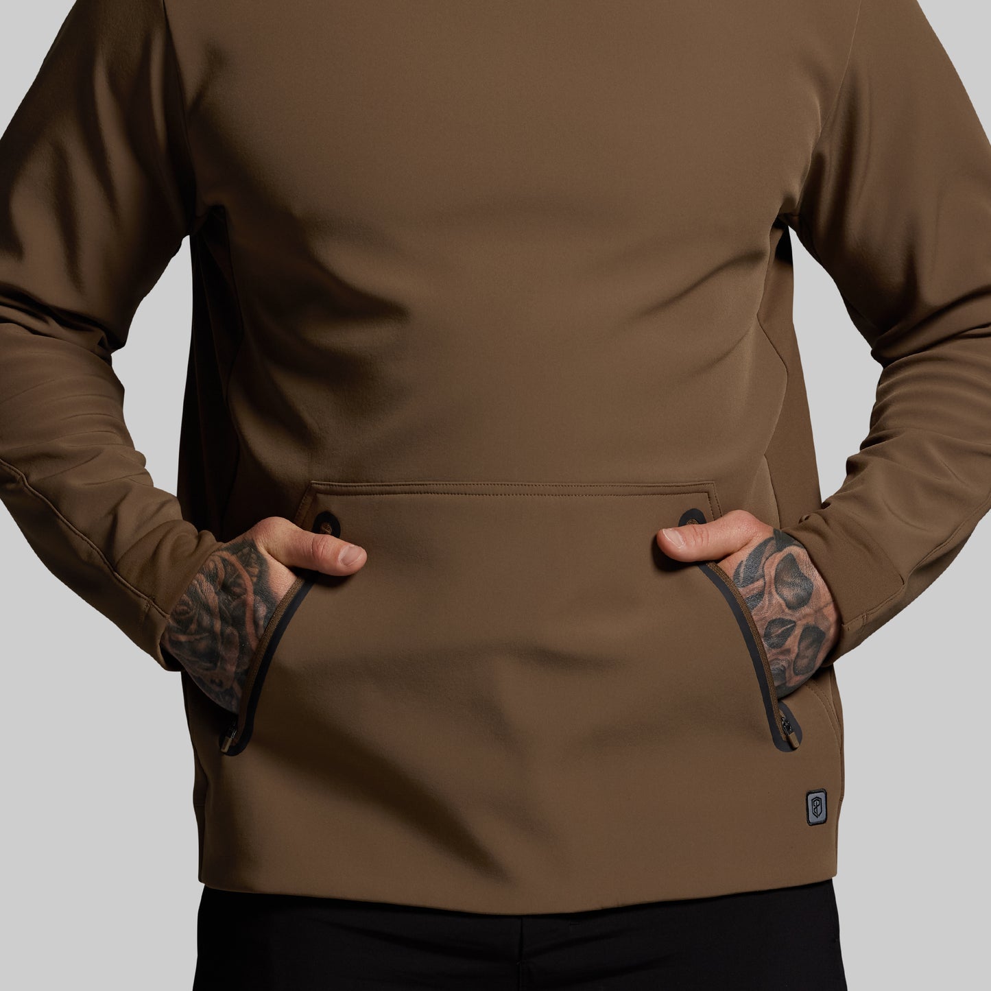Brown hoodie worn by a person on a gray background