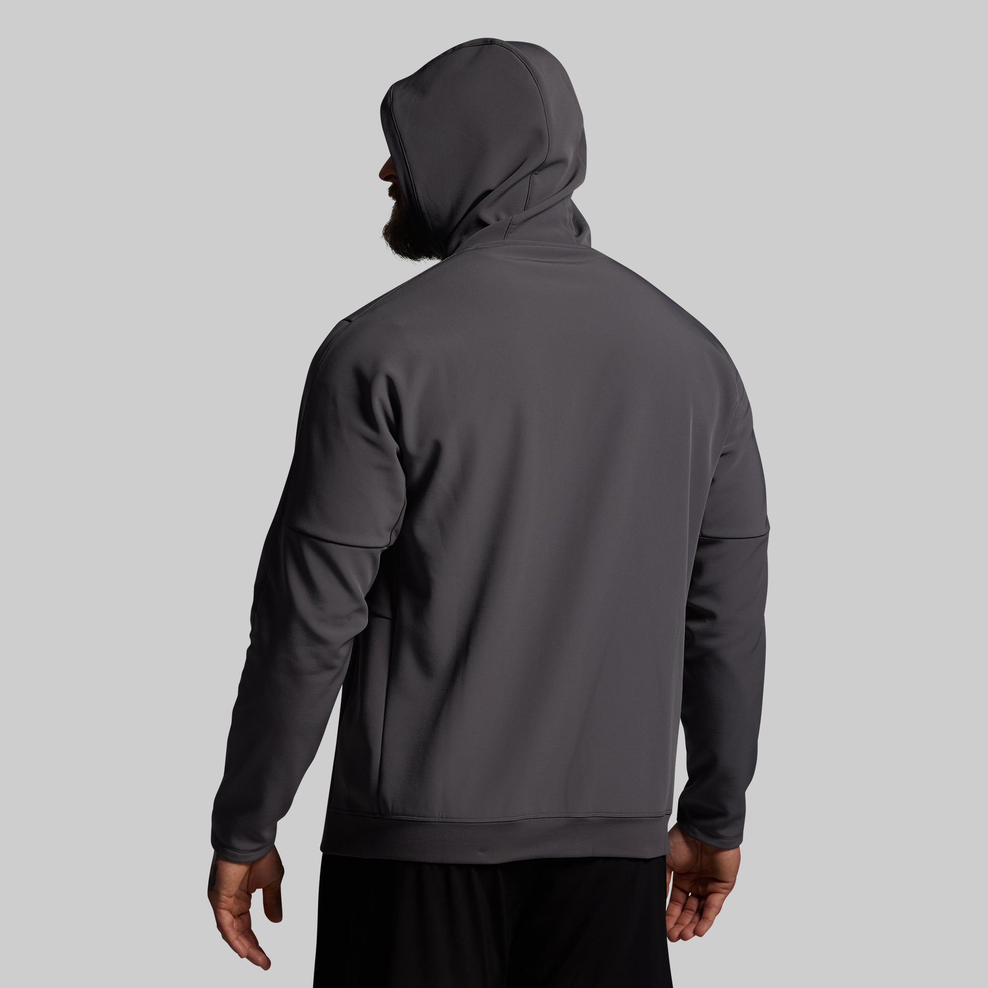 Person wearing a dark gray hoodie on a light gray background
