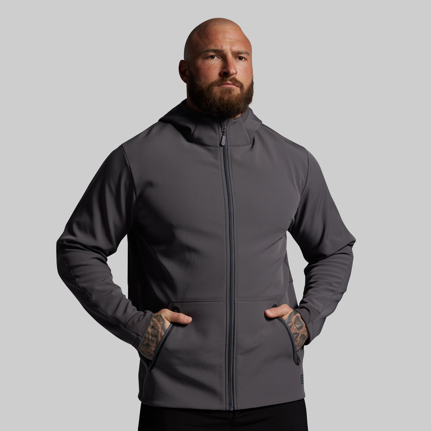 Man wearing a gray hoodie against a plain background