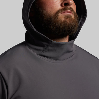 Person wearing a dark gray hoodie against a light gray background