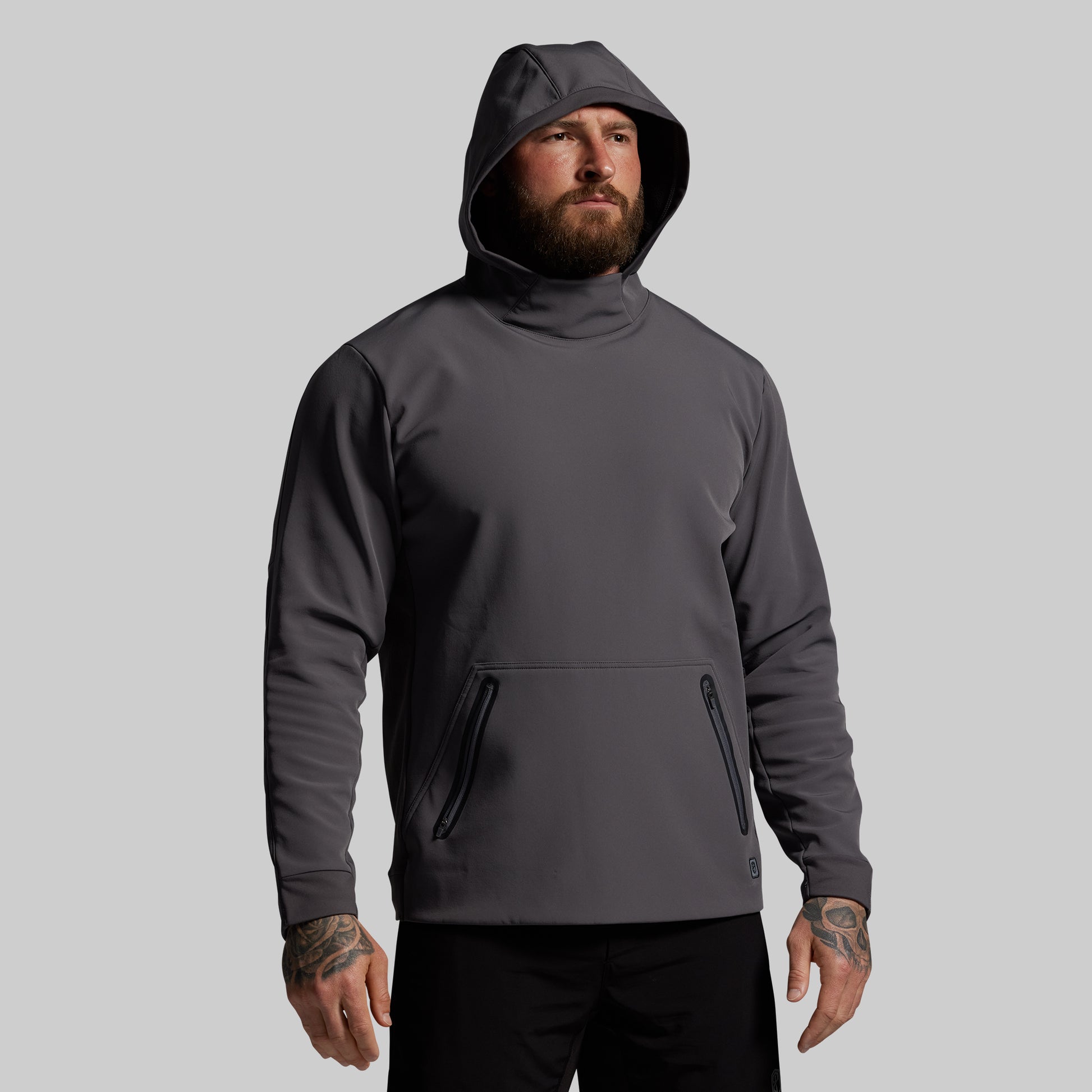 Man wearing a dark gray hoodie on a light gray background