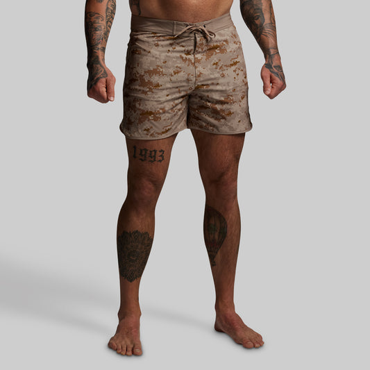 Person wearing camouflage shorts on a plain background